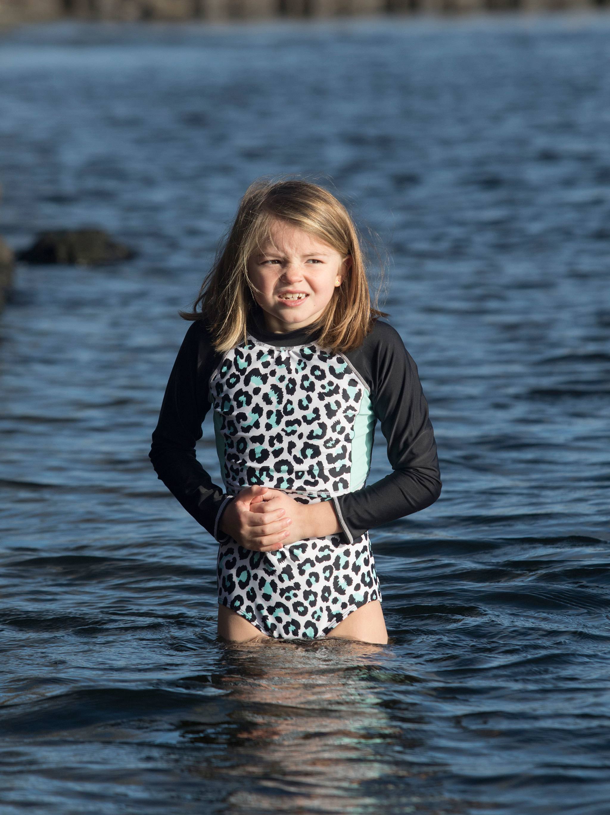 Helen Thacker, 7, of Renton, winces as she hits the frigid waters of Lake Washington at the Polar Bear Plunge at Clarke Beach on New Year’s Day.