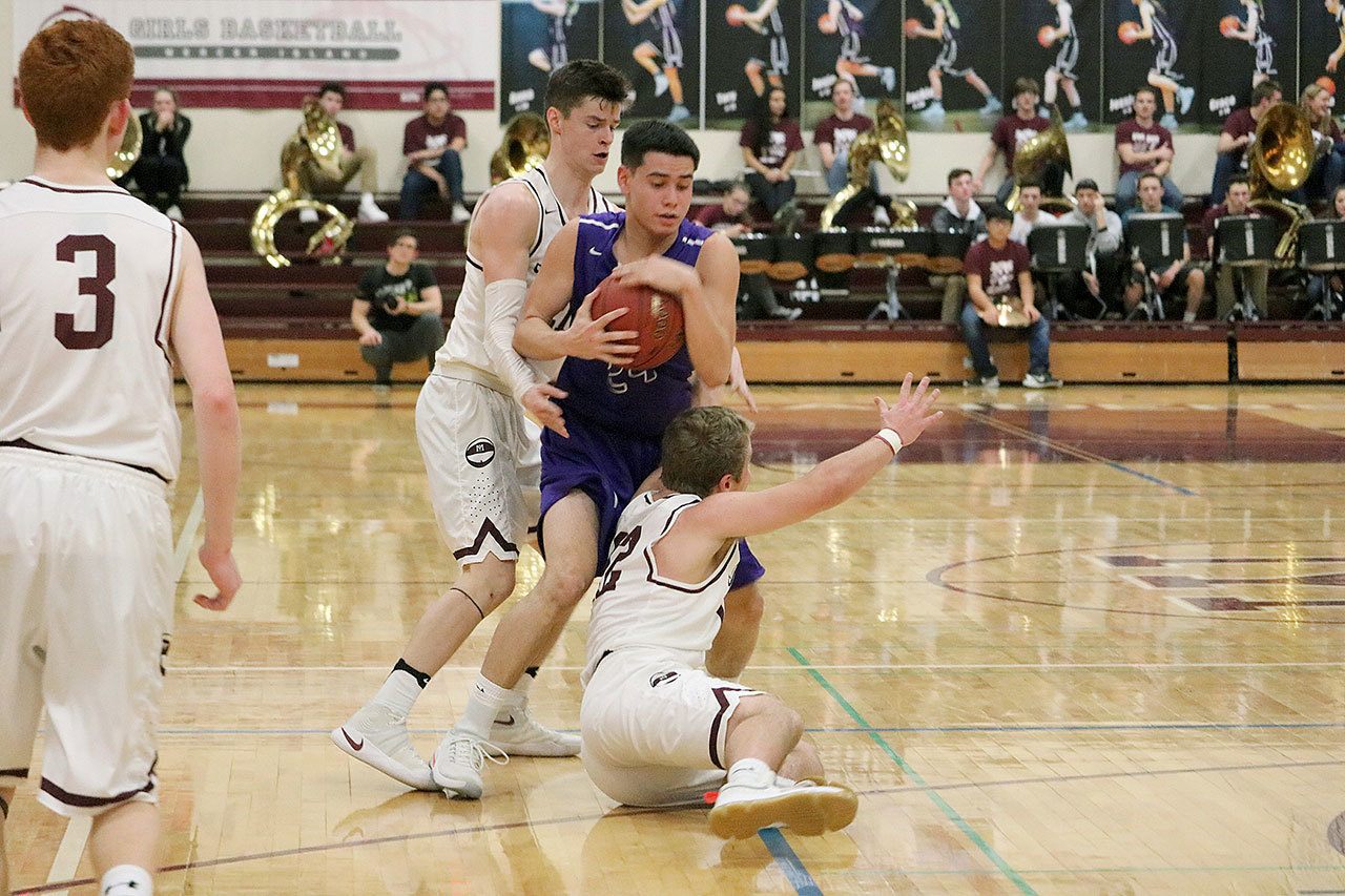 Lake Washington’s Jordan Richter fights for possession against Mercer Island’s Shain Scott (left) and Blake Swanson (bottom) Tuesday at Mercer Island High School. The Kangs beat the Islanders 48-42 (Joe Livarchik/staff photo).