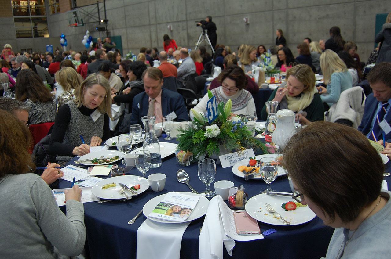 Islanders write checks to the MIYFS Foundation during the annual fundraising breakfast on Feb. 8. Katie Metzger/staff photo