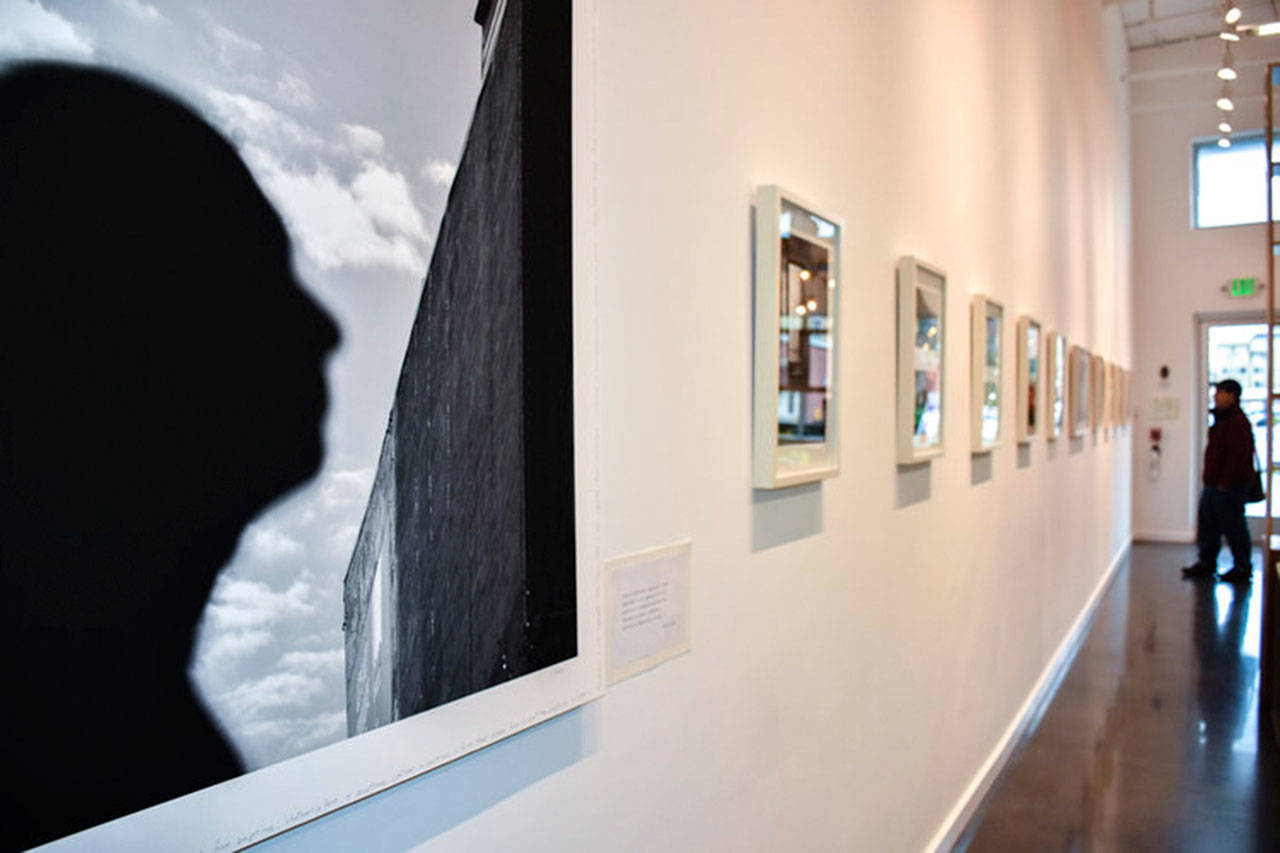 An art admirer looks at photos at SZ Art Gallery, which opened last March. Photo via www.suzannezahr.com