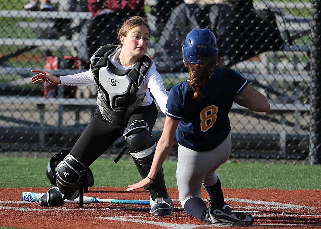 Photo courtesy of Jim Nicholson                                Mercer Island Islanders catcher Kayla Varney tags out a Bellevue runner at the plate in a battle between KingCo 3A rival squads. The Islanders defeated the Wolverines 12-11 on March 29.