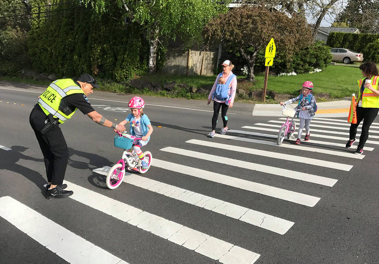 Officer Scott Hyderkhan greets riders as they make their way to school. Photo courtesy of MIPD