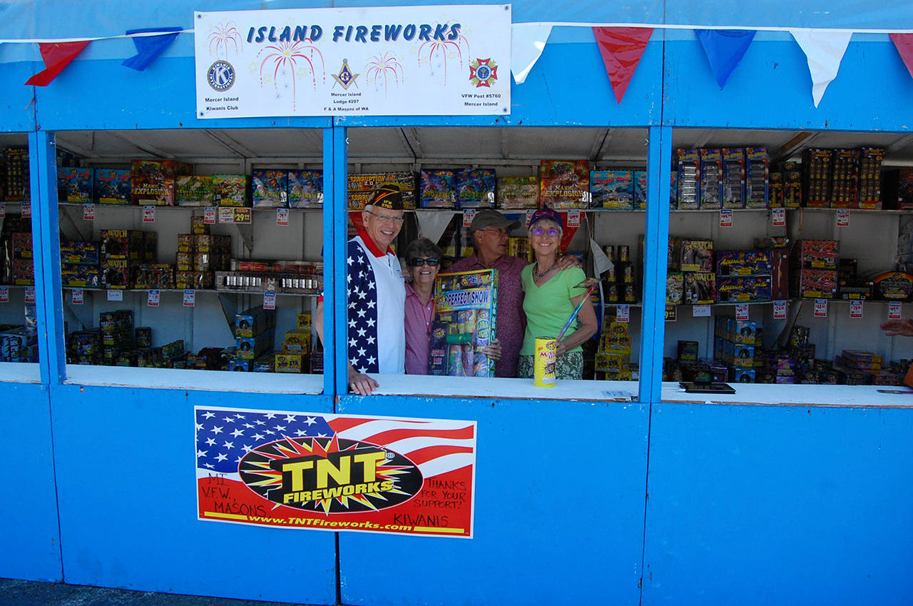Bob Harper with the VFW and Inge Lettini, Mike Tye and Sue Miller with Kiwanis sell fireworks to raise money for Mercer Island scholarships and community groups. Mercer Island is one of few cities in the Lake Washington area that allows consumer fireworks. Katie Metzger/staff photo