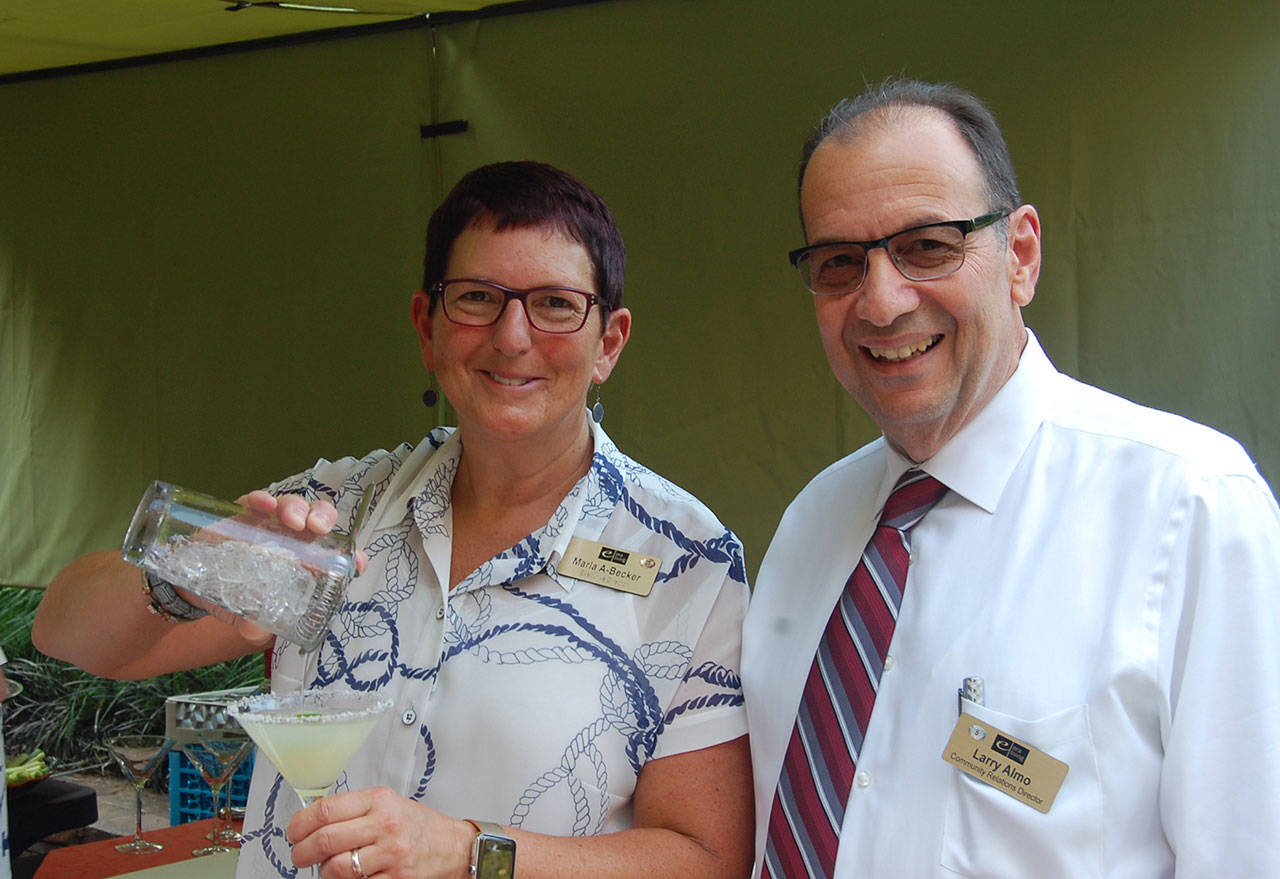 Marla Becker and Larry Almo of Aljoya smile at the 10th anniversary celebration of the Mercer Island Farmers Market, which was hosted by Aljoya in its garden patio. Katie Metzger/staff photo