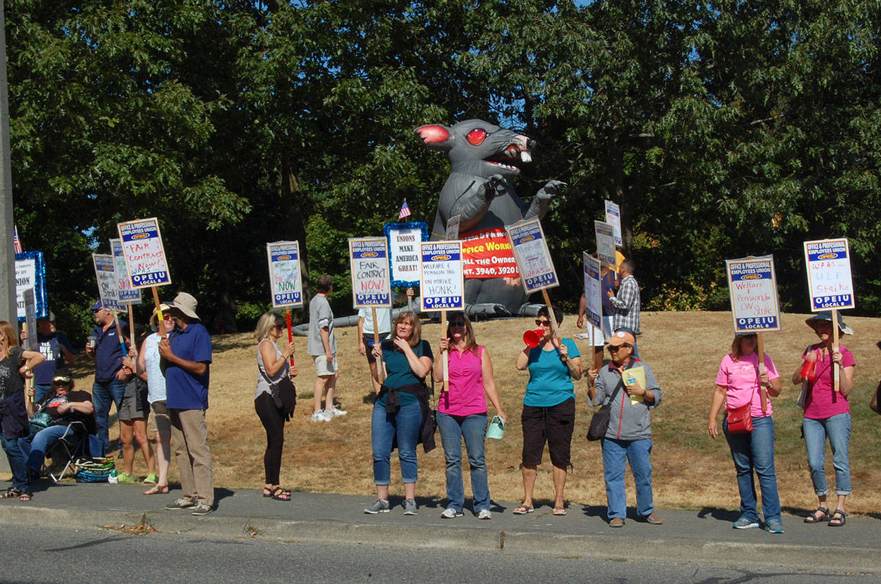Employees at Mercer Island-based Welfare and Pension Administration Service and members of OPIEU Local 8 picket along Southeast 24th Street on Sept. 14, holding up signs that encourage drivers passing by to honk to show support for unions. Katie Metzger/staff photo