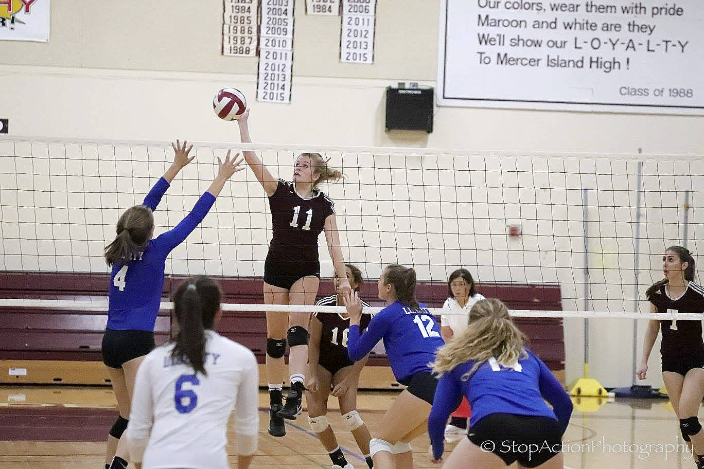 Photo courtesy of Don Borin/Stop Action Photography                                Mercer Island senior middle blocker Lindsey Lovsted, center, spikes the ball for a point against the Liberty Patriots on Sept. 27.