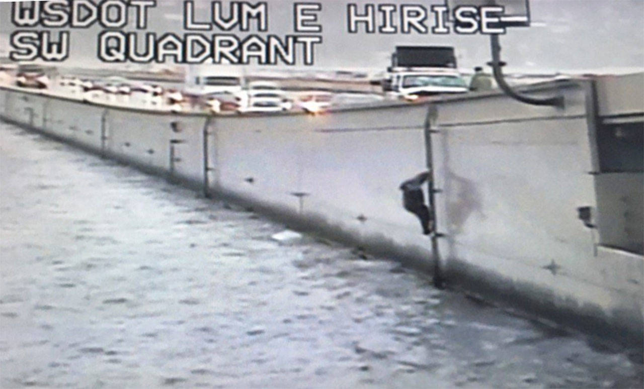 A capsized boater climbs onto the Interstate 90 bridge on Oct. 18. Photo courtesy of Washington State Patrol Trooper Rick Johnson‏ (@wspd2pio)