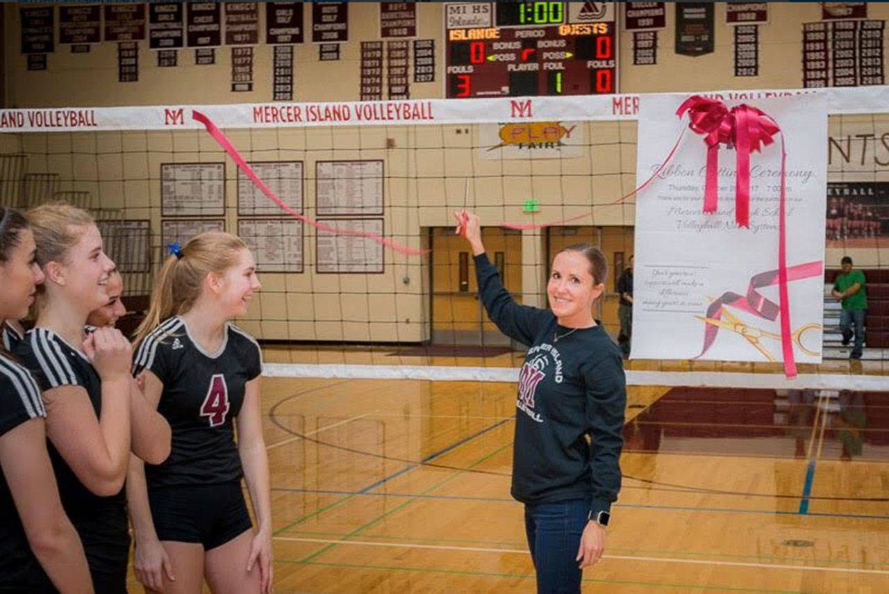MIHS volleyball coach Susan Rindlaub cuts the ribbon on the new net system. Photo via Twitter