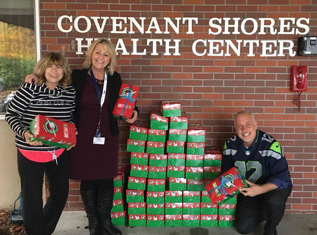 Mihaela Dimitriu, fitness coordinator at Covenant Shores, Roxanne Helleren, resident life director, and Chaplain Greg Asimakoupoulos pose with the shoeboxes assembled for Operation Christmas Child. Photo courtesy of Wendy D’Alessandro