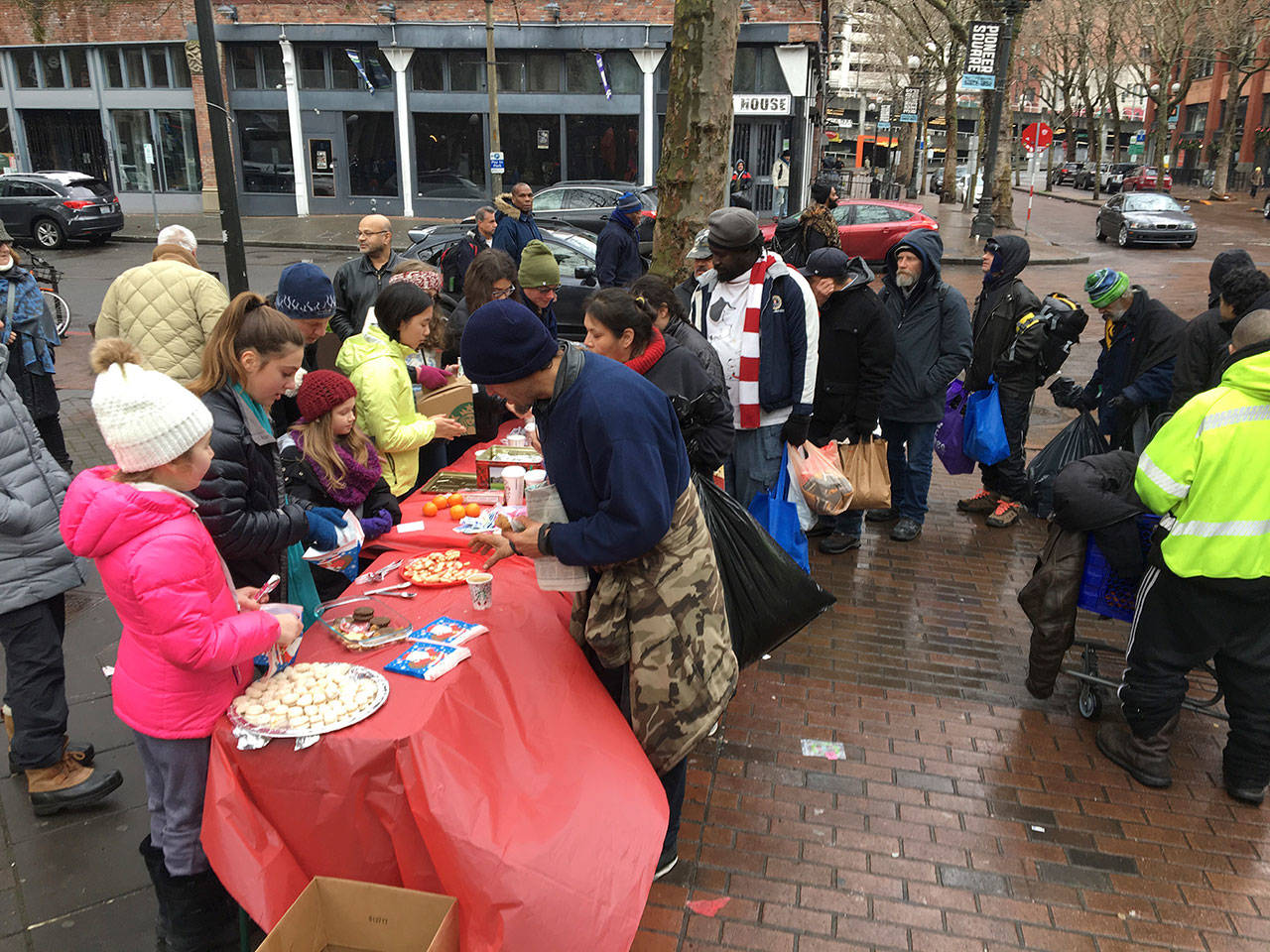 Mercer Island Cadette Girl Scout Troop 44297 members serve coffee, clementines and cookies in Pioneer Square on Dec. 25. Photo courtesy of Terese Broccoli