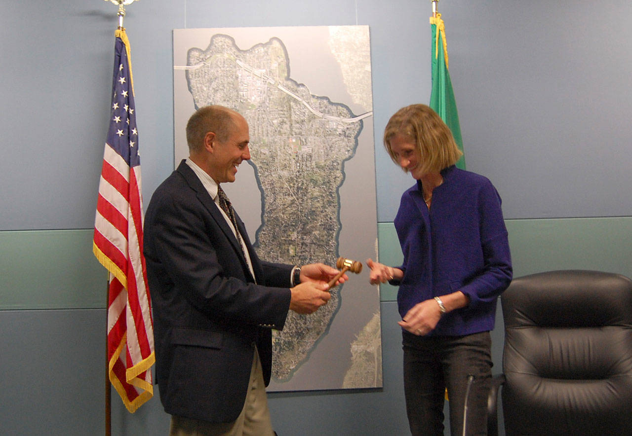 Former Mayor Bruce Bassett passes the gavel to new Mayor Debbie Bertlin at the Jan. 9 Mercer Island City Council meeting. Katie Metzger/staff photo