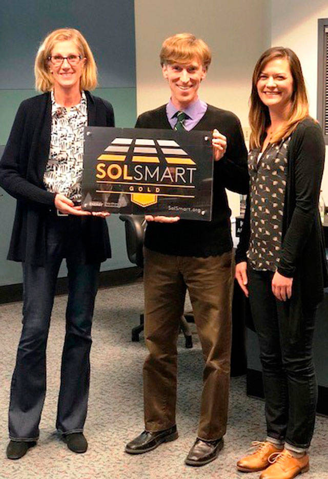 Mercer Island Mayor Debbie Bertlin, Sustainability Manager Ross Freeman and Spark Northwest ED Jennifer Grove pose with the SolSmart award on Jan. 23. Photo courtesy of the city of Mercer Island