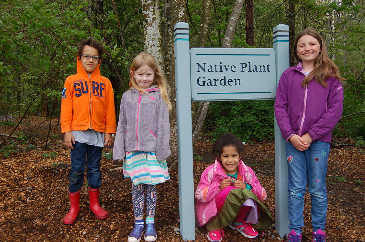 New Junior Naturalists pose at the newly installed Native Plant Garden sign with experienced guide Laura Drake (second from left) after her first Native Plant Garden tour. Photo courtesy of Patrick Daugherty