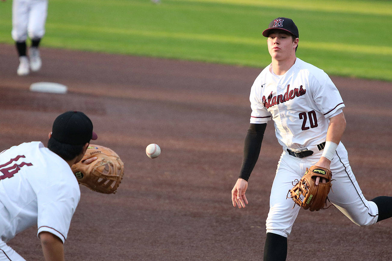 Andy Nystrom, staff photo                                Mercer Island infielder Cole Miller, right, tosses the ball to first baseman Justin Ho for an out in the top of the second inning against the Redmond Mustangs in a KingCo 3A playoff baseball game on May 3 at Bannerwood Park in Bellevue. Mercer Island, which trailed by four runs early in the game, earned a 7-6 comeback win.