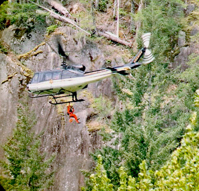The SnoHAWK10 helicopter of the Snohomish County Sheriff’s Office on Saturday lowered a rescue technician and flight medic to treat a man who fell while climbing the Index Town Wall. (Snohomish County Sheriff’s Office)