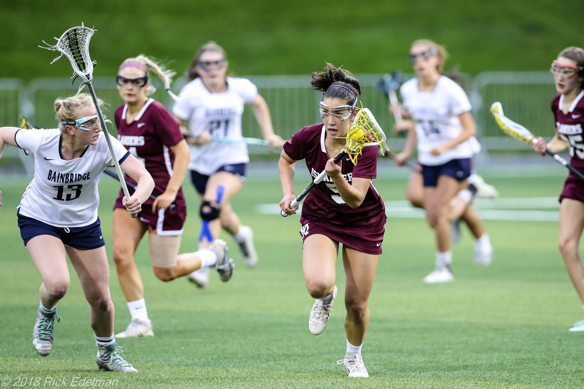 Photo courtesy of Rick Edelman/Rick Edelman Photography                                Mercer Island player Grace Fujinaga, who scored three goals in the state title game, carried the ball upfield while being chased by Bainbridge Island player Maggie Sweeney (left).