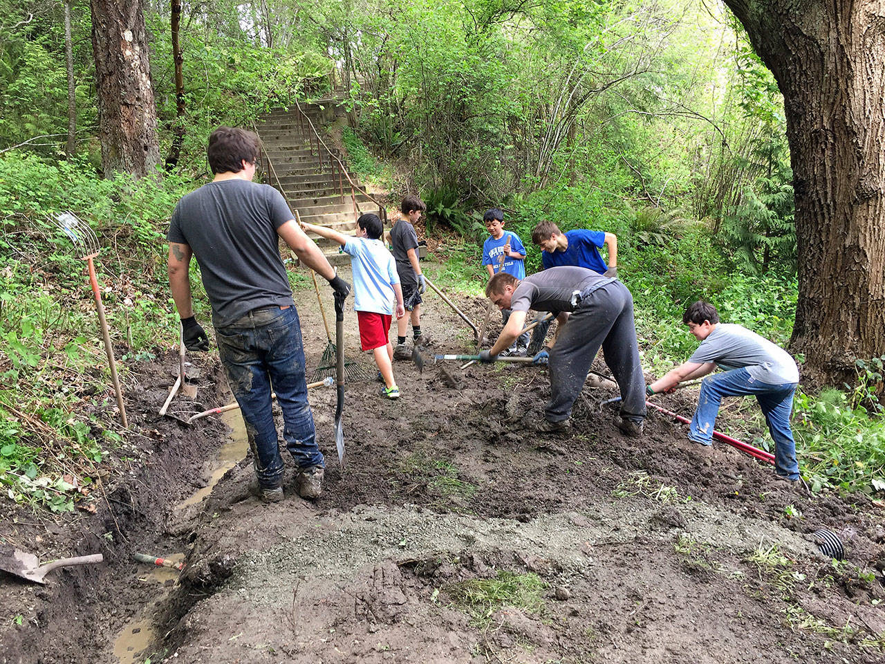 Scouts from Troop 457 dig ditches to enhance the drainage above Mercerdale Park as part of Mark Mangino’s Eagle Project.