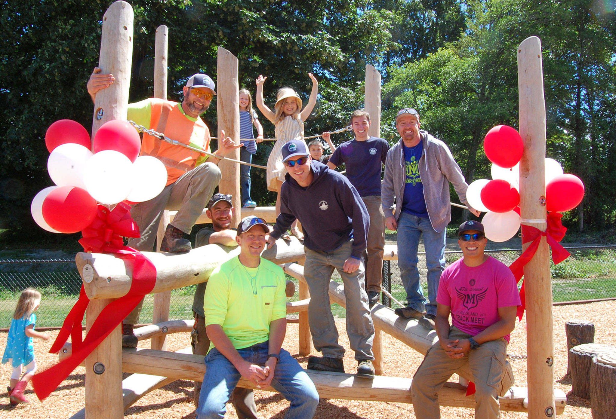 Mercer Island Parks and Recreation staff members smile with kids on the log jam structure at the Island’s newest playground. Katie Metzger/staff photo