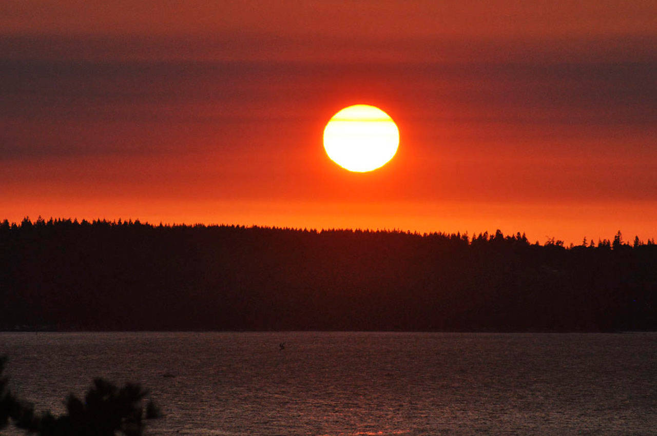 The smoky air makes for colorful sunsets, such as this one over Possession Sound on Monday evening. Sue Misao/Sound Publishing