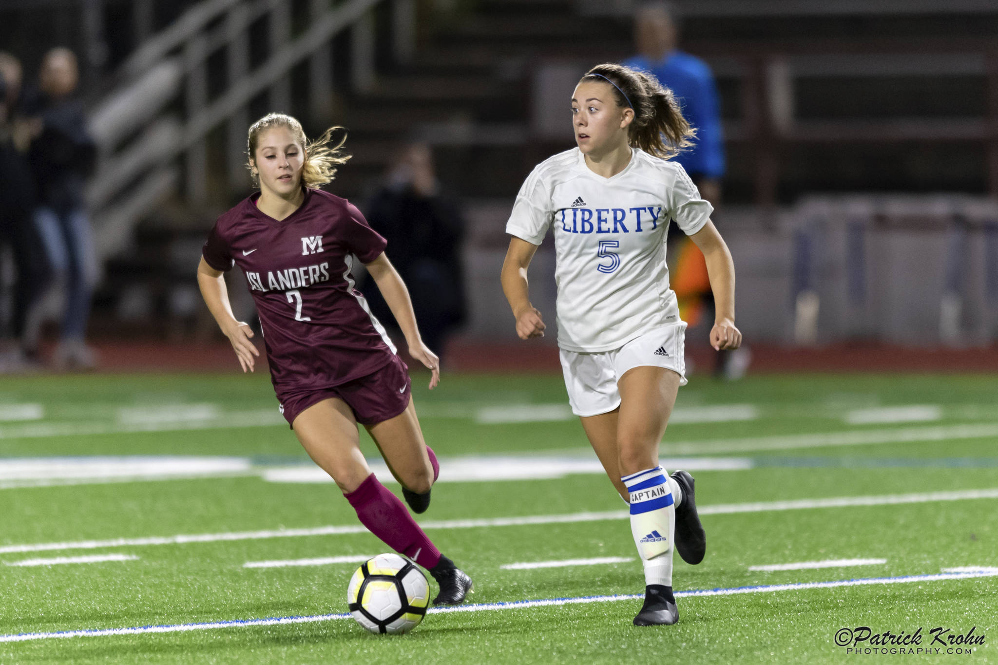 Mercer Island senior midfielder Emily Arron, left, puts pressure on Liberty defender Cameron Nelson, right, in a matchup featuring two of the top soccer programs in the 3A/2A KingCo Division. Mercer Island earned a 2-1 comeback victory on Sept. 25 on Mercer Island. Photo courtesy of Patrick Krohn/Patrick Krohn Photography