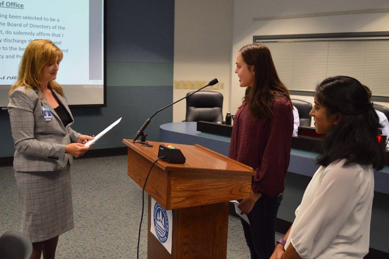 Superintendent Donna Colosky, left, administers the oath of office to Mercer Island High School student Caroline Atkinson, middle, as fellow student representative Meghana Kakubal, right, looks on. Atkinson and Kakubal are the first student representatives on the Mercer Island School Board. They took the oath at a Sept. 13 school board meeting. As nonvoting student representatives, Atkinson and Kakubal will attend the first regular board meeting of each month and report on student activities around the school district. Photo courtesy of Craig Degginger,communications coordinator for Mercer Island School District.