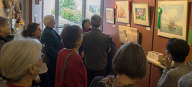 A group reviews the awards at the 2017 MIVAL Holiday Show at Mercer Island Community and Event Center. Photo courtesy of Mary Pat Mansfield