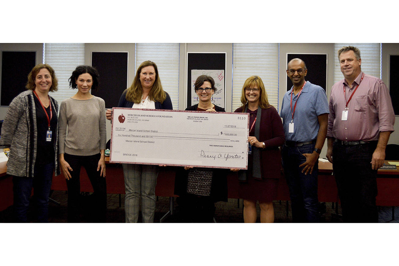 From left, Mercer Island School Board director Deborah Lurie, Mercer Island Schools Foundation (MISF) board member Tema Burkey, MISF development director Tammy Shoop, School Board president Tracy Drinkwater, Superintendent Donna Colosky, school board director David D’Souza and school board vice president Ralph Jorgenson pose for a photo after MISF presented a $600,000 check to the school board. Photo courtesy of Mercer Island School District