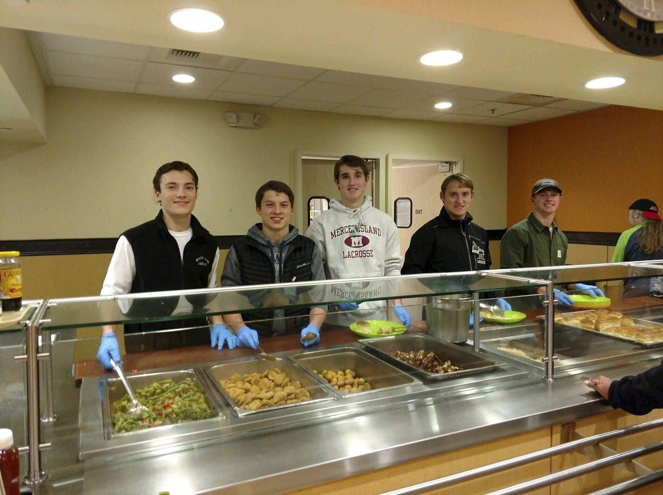 Members of the Mercer Island Lacrosse Club spent the evening of Dec. 12 volunteering at the Union Gospel Mission’s Hope Place in Seattle. The players prepared and served dinner to more than 100 guests who enjoyed a meal of chicken satay, rice, peanut sauce, mixed vegetables, fruit skewers and a brownie sundae bar. The Union Gospel Mission’s Hope Place is a shelter that serves women and children. Mercer Island boys lacrosse players Peter Davis, Paul Murdoch, Hunter Johnson, Rurger Marks and Stu Vassau are pictured in the above photo. Photo courtesy of Maryellen Johnson