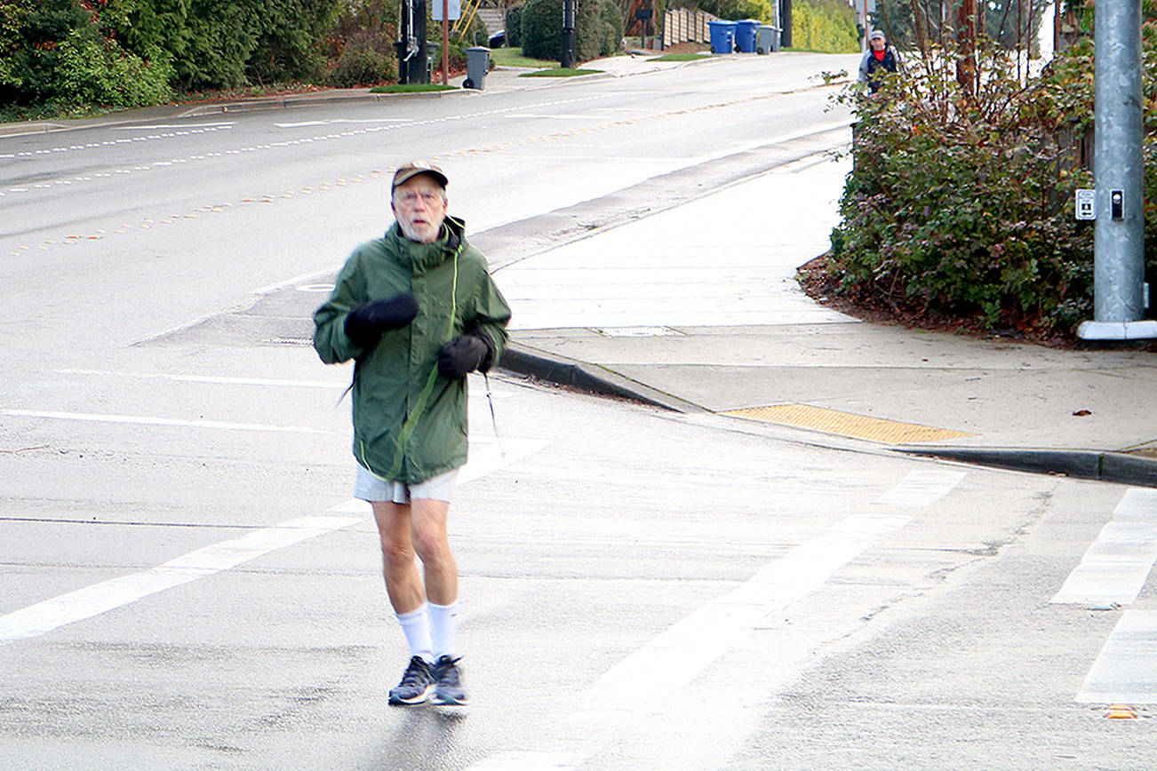 Mercer Island resident Steven Schickler jogs down a crosswalk between SE 40th ST and Island Crest Way Thursday Morning. Drew Stuart/staff photo.