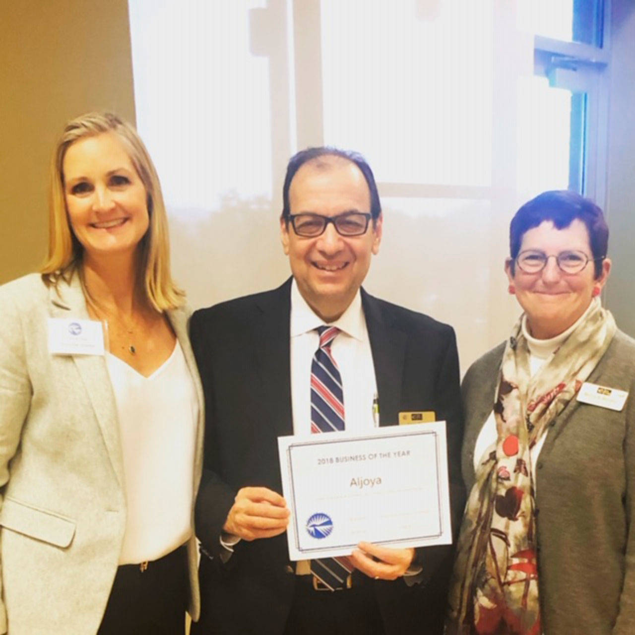 Chamber Director Laurie Givan presents the 2018 ‘business of the year’ award to Larry Almo and Marla Becker of Aljoya Mercer Island. Photo courtesy of Laurie Givan