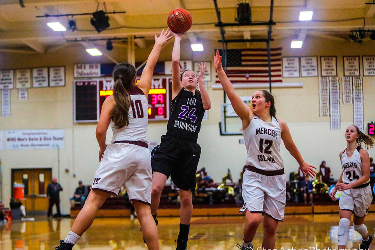 The Lake Washington Kangaroos girls basketball team captured a 64-53 win against the Mercer Island Islanders on senior night on Jan. 30 at Mercer Island High School. The Islanders dropped to 1-18 overall with the loss. Mercer Island seniors Sarah Gest, right, and Rio Beutelspacher, left, try to stop Lake Washington guard Rosa Smith, center, as she drives to the hoop. Photo courtesy of Don Borin/Stop Action Photography