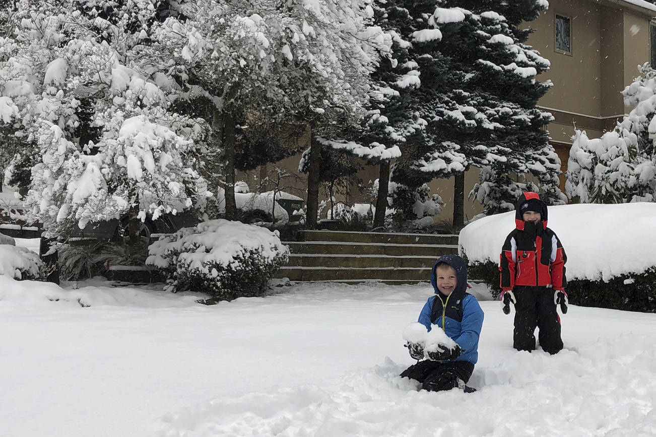 Mitchell Dudley, left, and Benny Erickson begin the frigid but exciting task of building a snow fort. Residents awoke on Monday, Feb. 4, to a blanket of snow, closed schools and icy roads. See story on Page 13. Photos by Greg Asimakoupoulos