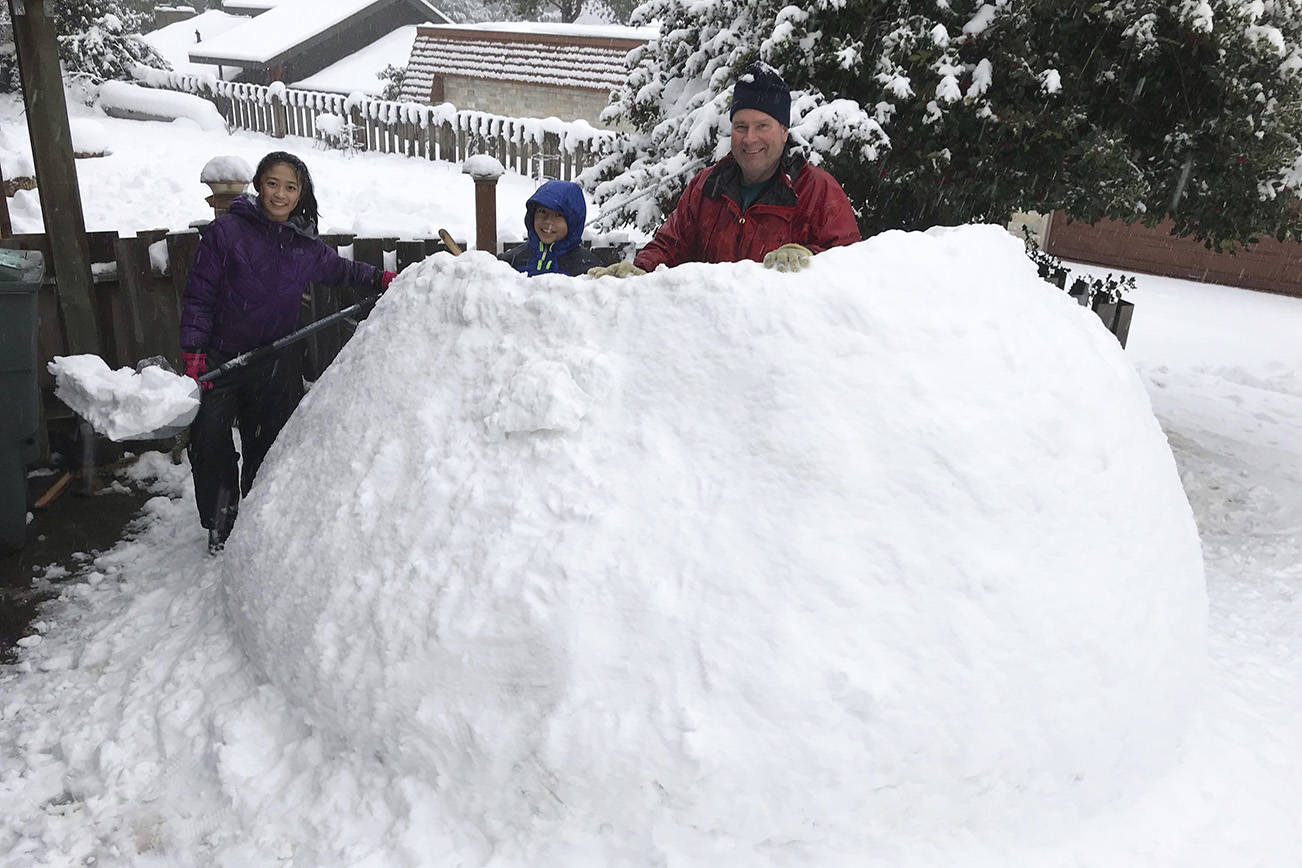 Jayne, Dan and Derek take a break to pose for a photo while building an igloo on Mercer Island. Photo courtesy of Meg Lippert