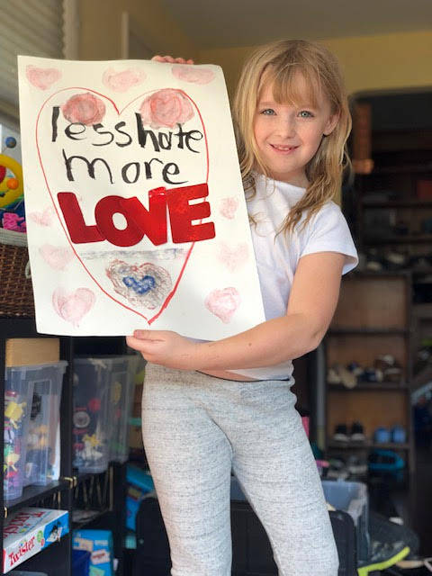 Photo courtesy of Ashley Sternberg                                 8-year-old Lucy Sternberg holds up her sign, created for a community rally on Mercer Island.