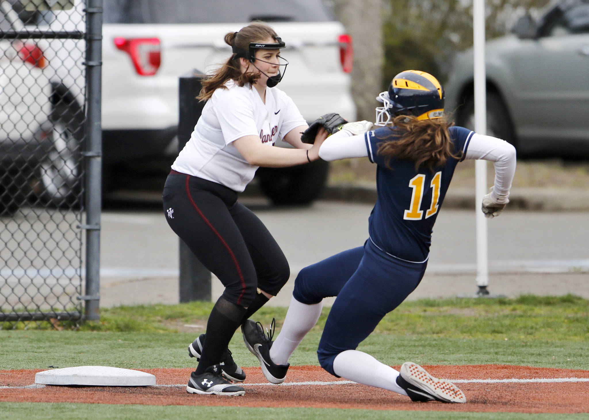 Mercer Island third baseman Caitlyn Barber, left, tags out Bellevue baserunner Rachel Treves, right, during a matchup between rivals on April 3 at the South Mercer playfields. Bellevue defeated Mercer Island, 35-0. Photo courtesy of Jim Nicholson