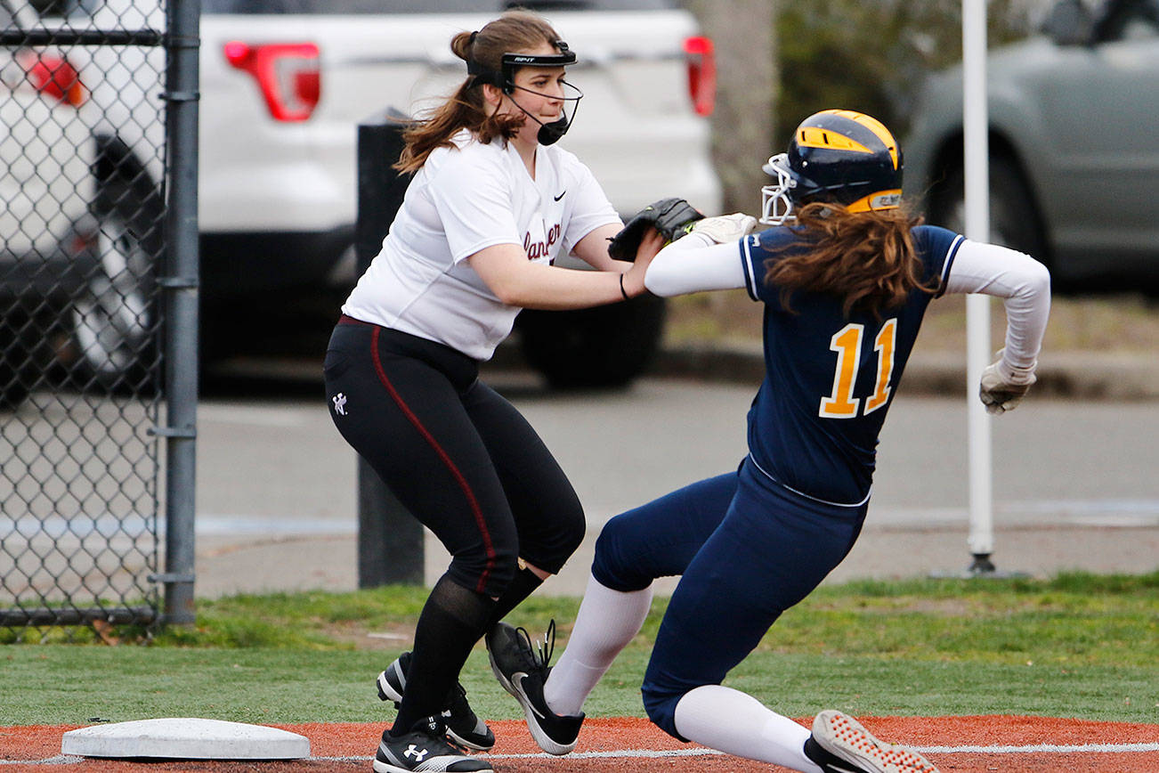 Mercer Island third baseman Caitlyn Barber, left, tags out Bellevue baserunner Rachel Treves, right, during a matchup between rivals on April 3 at the South Mercer playfields. Bellevue defeated Mercer Island, 35-0. Photo courtesy of Jim Nicholson