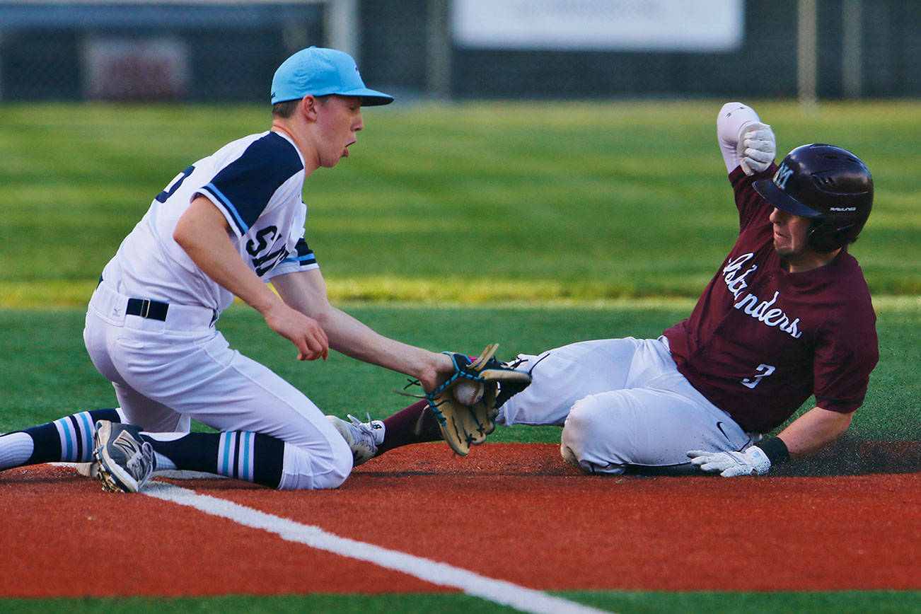 Mercer Island Islanders senior Max Tanzer, right, slides safely into third base on a close play while being tagged by Interlake third baseman Charlie Galanti in the top of the fourth inning. Mercer Island defeated Interlake, 11-0, on April 17 in Bellevue. Photo courtesy of Jim Nicholson