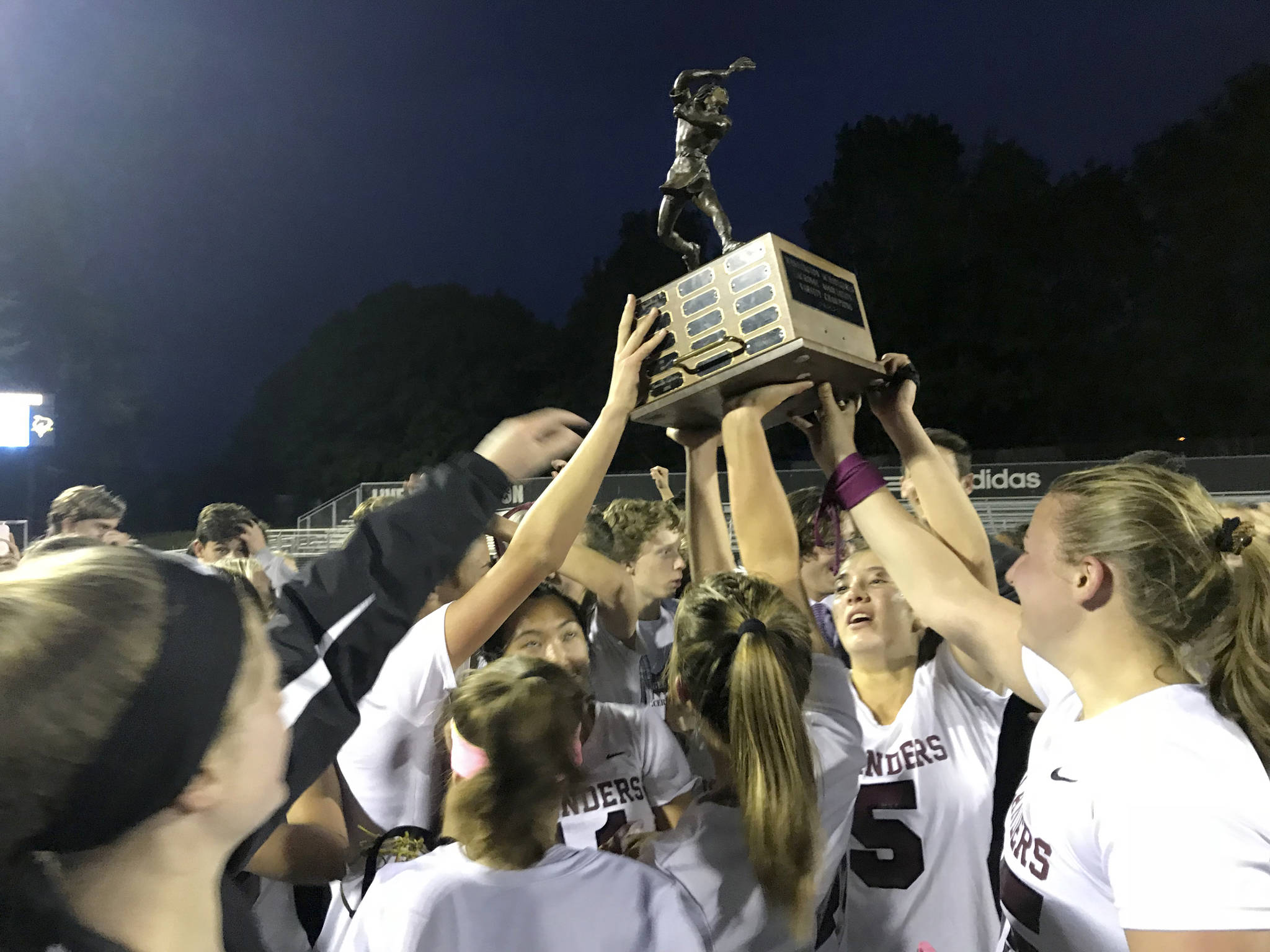 The Mercer Island Islanders girls lacrosse team hoists the state championship trophy following its 10-9 win against Bainbridge Island on May 17. Shaun Scott/staff photo