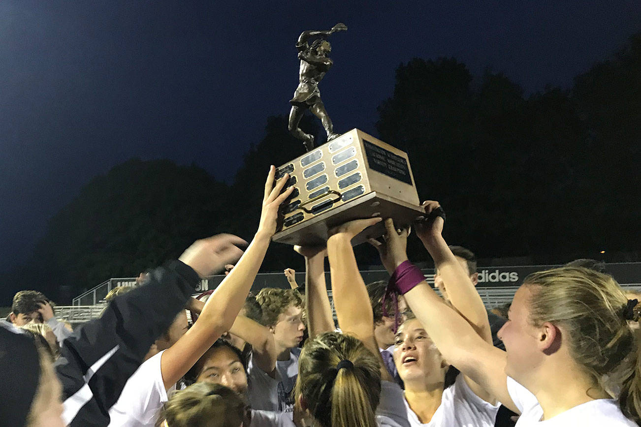 The Mercer Island Islanders girls lacrosse team hoists the state championship trophy following its 10-9 win against Bainbridge Island on May 17. Shaun Scott/staff photo