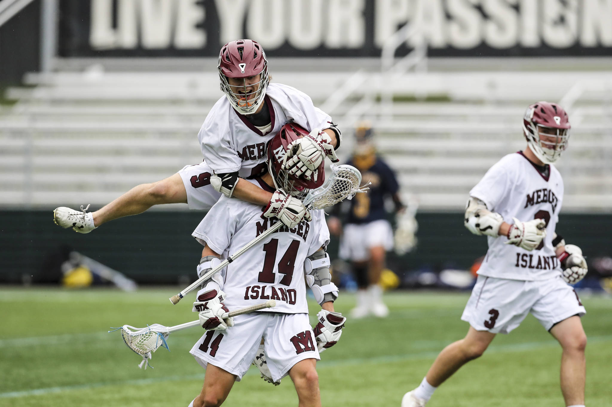 Mercer Island player Glen Mahony (No. 9) leaps on the back of Will Wheeler (No. 14) during the 3A state championship game against the Bellevue Wolverines. Mercer Island defeated Bellevue 14-6 on May 25 at the Starfire Sports Complex in Tukwila. Photo courtesy of Rick Edelman/Rick Edelman Photography