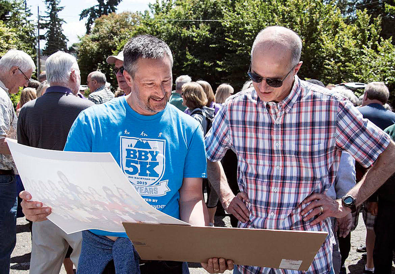 Mark LeMaster and Stu Harris look at past class photos during the East Seattle Elementary School alumni event on June 8. Photo courtesy of Owen Blauman