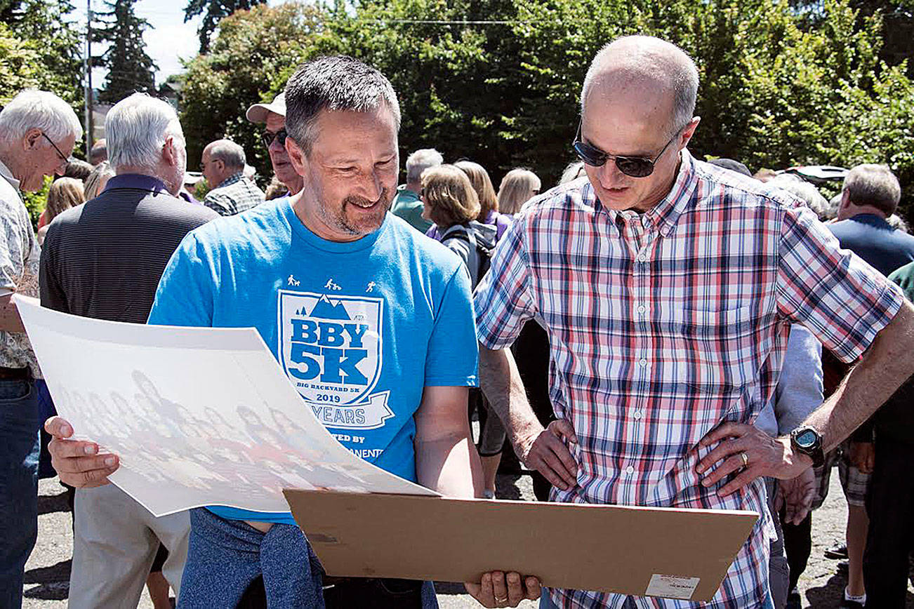 Mark LeMaster and Stu Harris look at past class photos during the East Seattle Elementary School alumni event on June 8. Photo courtesy of Owen Blauman