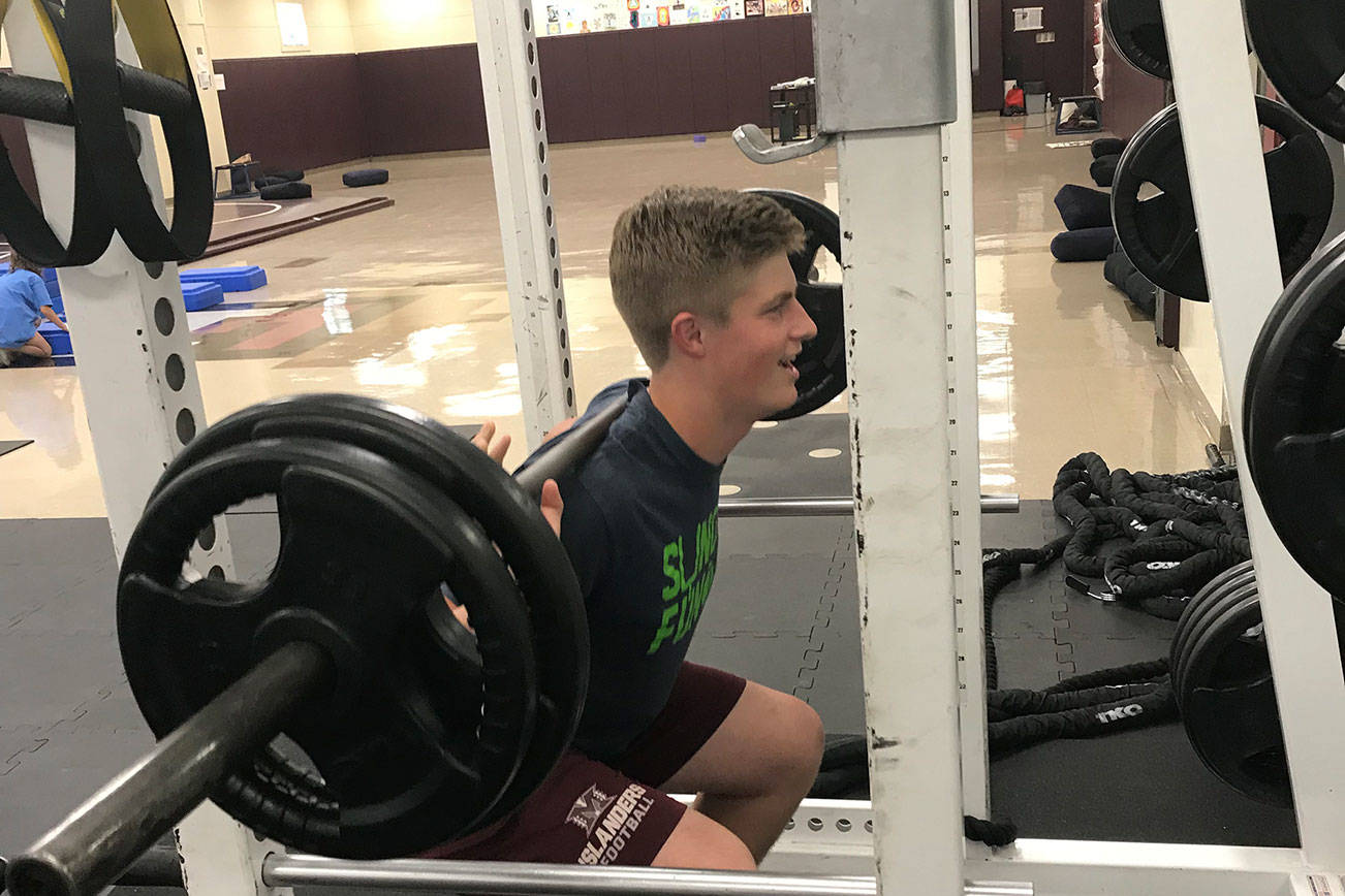 Mercer Island quarterback Clay Dippold completes a set of reps on the squat rack in the weight room on June 14. Shaun Scott/staff photo