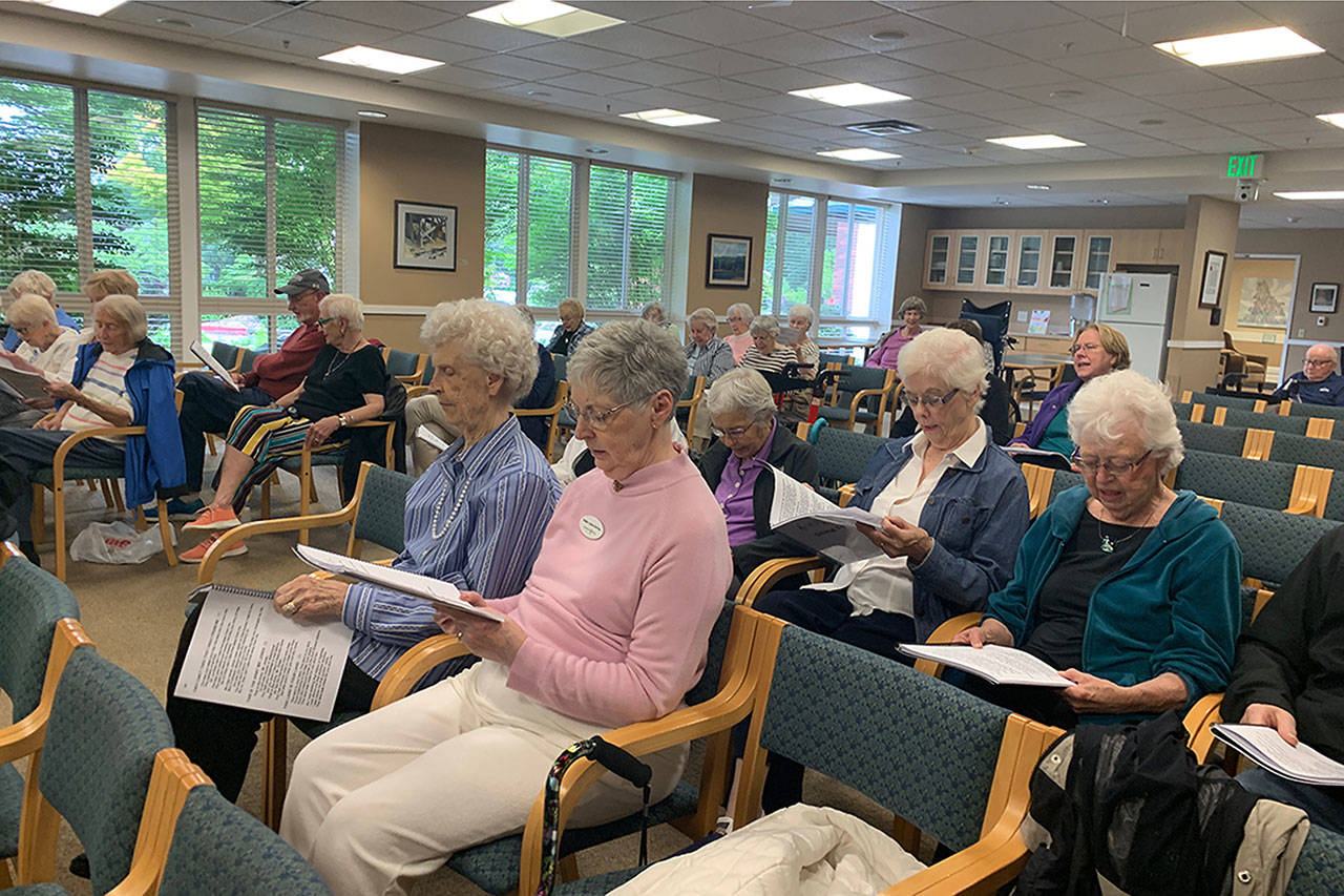 Mercer Island seniors sing from their songbooks in the Fellowship Hall at Covenant Living at the Shores on July 17. Madeline Coats/staff photo                                 Pastor Greg Asimakoupoulos and Rotarian Karen Dunning guided the group through 15 songs during the sing-a-long program. Madeline Coats/staff photo