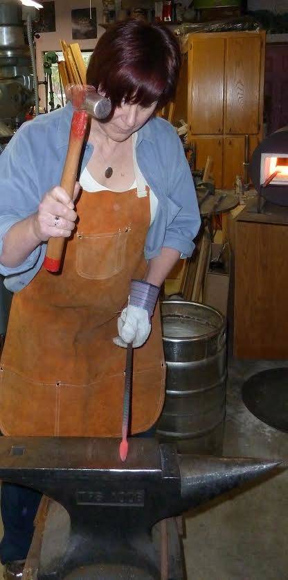 Author Claire Gebben gives blacksmithing a go at Bruce Weakly’s private shop on Whidbey Island. Gebben sought to learn the art of blacksmithing to better understand the life of her great-great grandfather, who immigrated to Cleveland in the mid-1800s. Photo courtesy of Claire Gebben