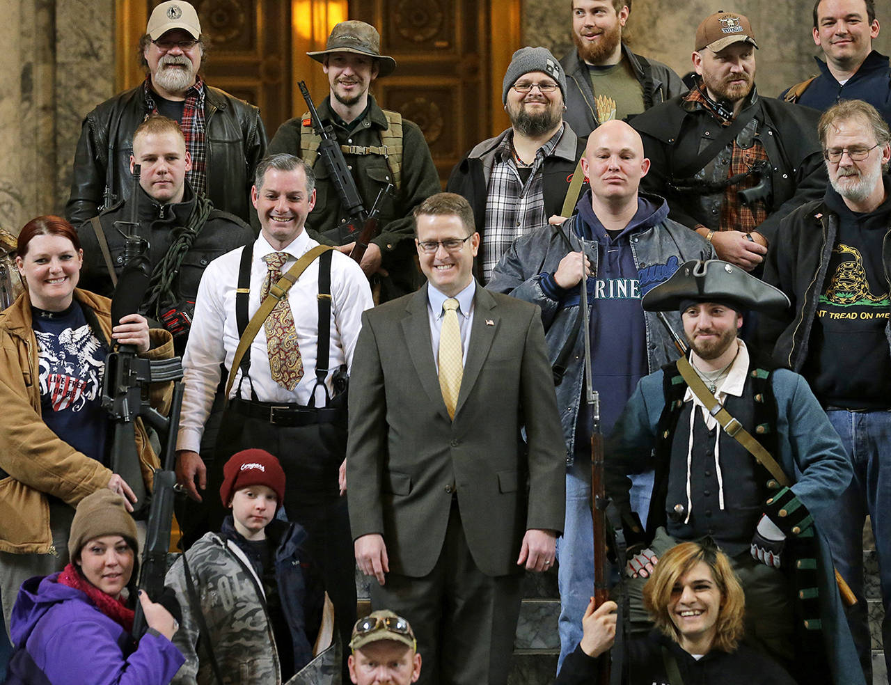 In this 2015 photo, Washington Rep. Matt Shea, R-Spokane Valley (center), poses for a group photo with gun owners inside the Capitol in Olympia, following a gun-rights rally. (AP Photo/Ted S. Warren, File)