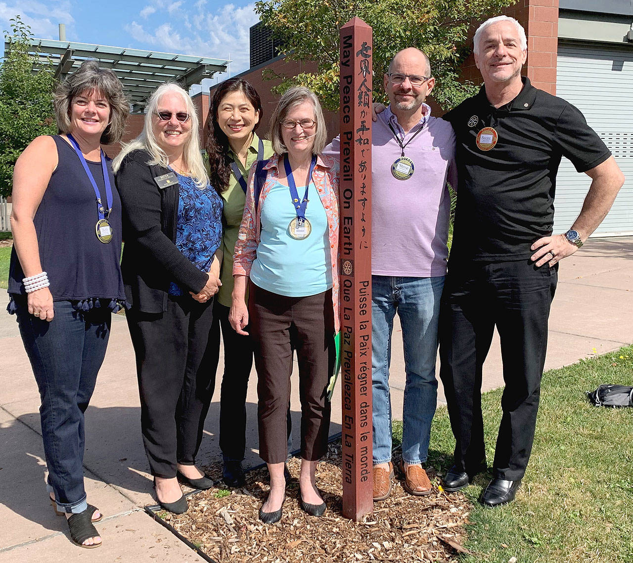 Mercer Island rotarians Beth Baska, Becca Palm, Soonok Kwak, Carol Friends, Steve DeVos and Brent Jordan standing with one of the island’s 20 peace poles. Picture by Tracy Drinkwater