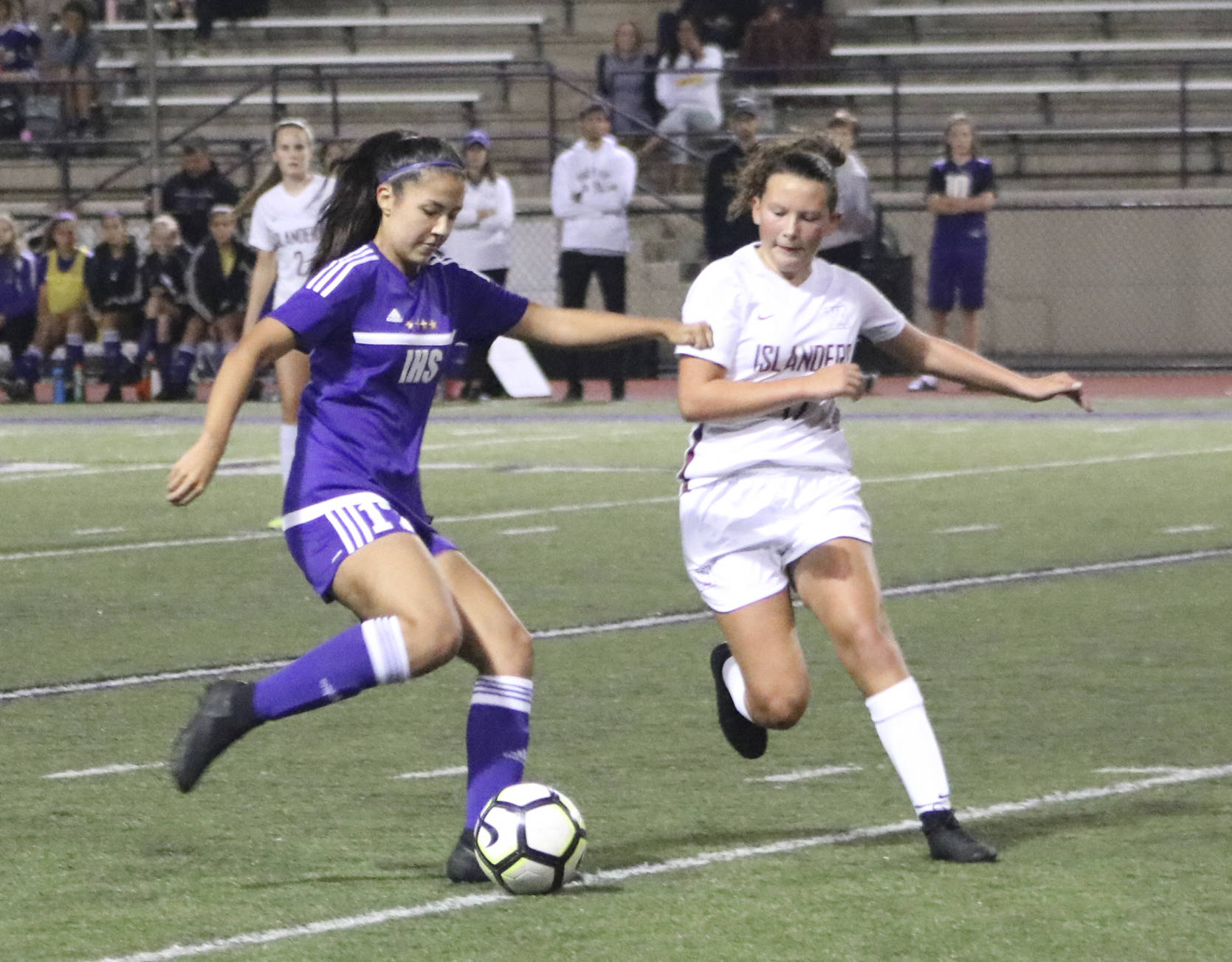 Islanders freshman Arden Paglia (in white) tries to take the ball off Eagles midfielder Kira Terao (in purple) during a 6-0 loss to Issaquah. Benjamin Olson/ staff photo