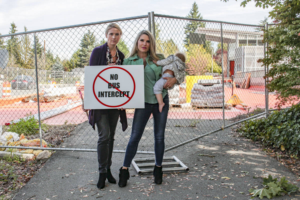 Natalie DeFord/staff photo                                From left, Ashley Hay and Olivia Lippens with baby Monroe in protesting the bus intercept plan in front of the future Mercer Island light rail station.