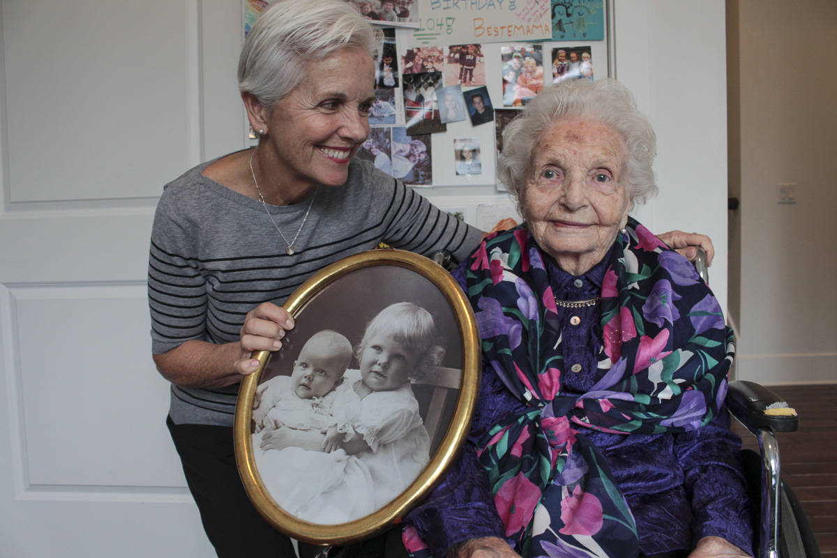 Natalie DeFord/staff photo                                Mercer Island resident Mary Ann Flynn and her mother, Aagot Kate Rosellini, who is turning 106 years old. They are holding a picture of Rosellini and her younger sister when they were small children.